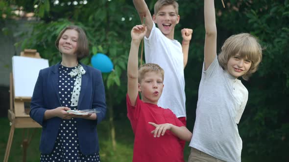 Confident Talented Creative Children Looking at Camera Gesturing with Painting Brushes Smiling alt