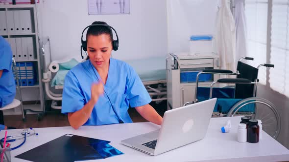 Surgeon Assistant Using Headphones in Hospital Answering To Patients Calls alt