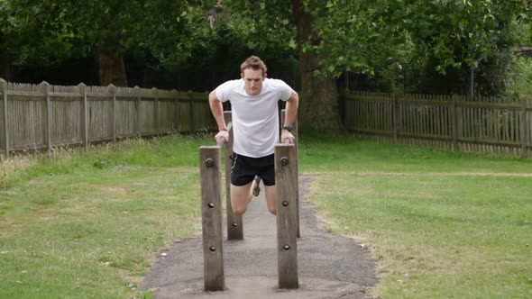 Male fitness training on parallel dip bar alt