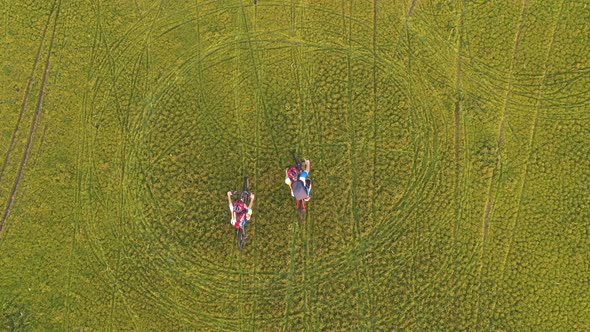 Footage B Roll 4k. Aerial view Drone tracking young People riding a bikes on the meadow