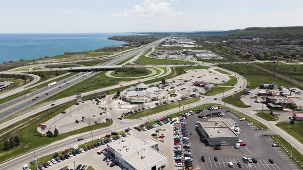Aerial backwards shot showing traffic on highway and parking cars at market near Grimsby Town in Can alt