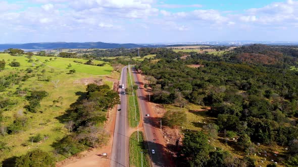 A scenic highway through the green summer countryside - pull back aerial view alt