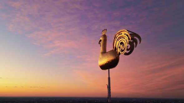 Traditional Golden Weather Cock or Rooster in Riga Looking in Bright Future During Vivid Sunrise alt