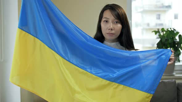 Portrait of an Asian Woman with the Ukrainian Flag in Her Hands