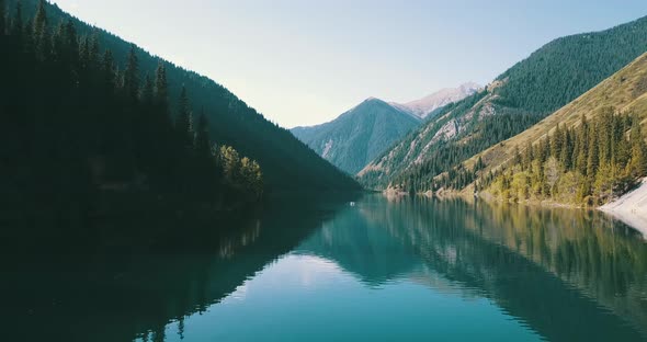 Beautiful landscape of mountain lake, Emerald water surrounded by coniferous forest, autumn grass alt