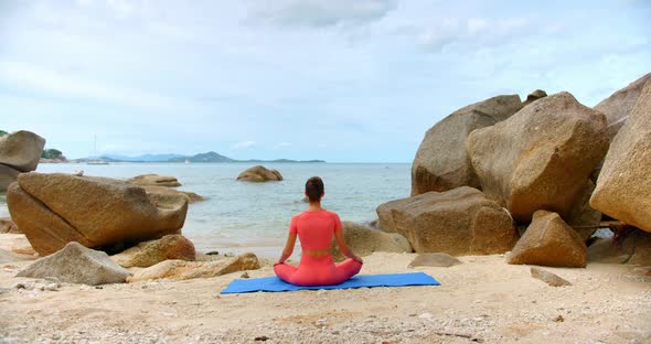 Bach Shot of a Woman She Seats in Meditation Pose By the Sea Line on Blue Yoga Mat alt