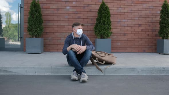 Young Man with a Medical Mask Looked Around and Stand Up To Go alt
