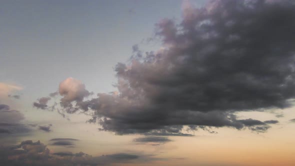 Wideangle Panorama of a Dark Evening Sky with Blue Clouds in Sunlight alt