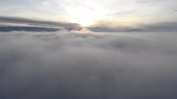 Incredible Aerial View Shot Above Swirling Fog and Clouds at Sunset in the Mountains alt