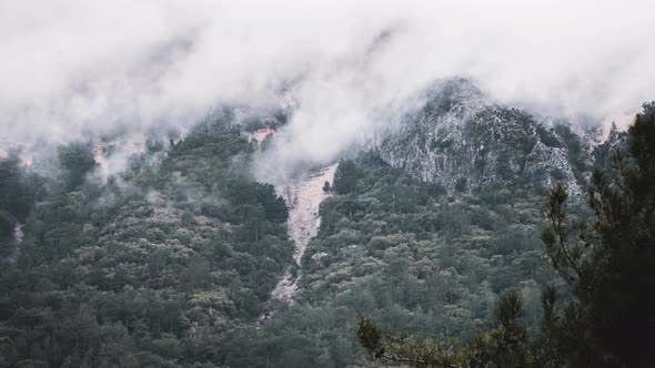 Clouds and mist clearing over a mountainside time lapse