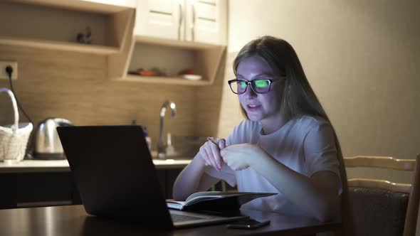 Young Girl Working From Home on the Kitchen and Does Online Teaching, Evening