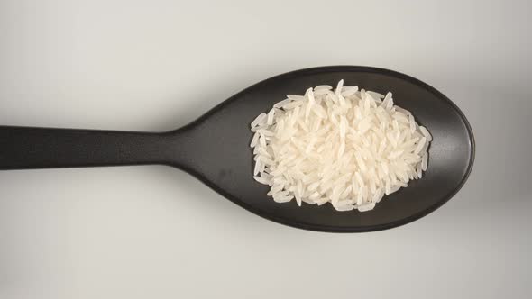 Black Spoon Is Filling By A White Rice alt