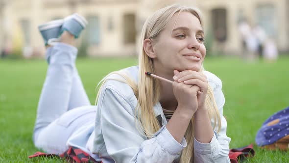 Blonde Woman Lying on The Green Grass and Relaxing