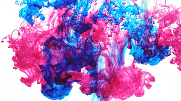 Series of blue and pink ink drops falling into the water and slowly dissolve alt