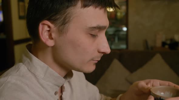 Tea Lover Drinks Tea From Bowl Closeup. Man Tasting Traditional Chinese Tea alt