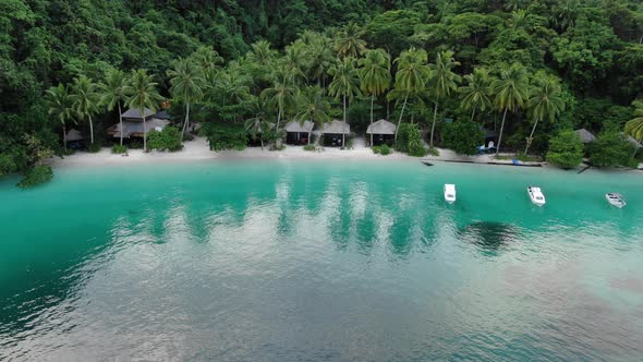 Boats Near Ocean Beach With Huts Among Palm Trees In Triton Bay, Raja Ampat.  alt