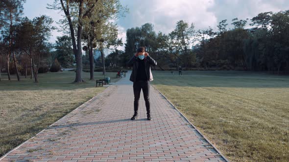 A Wide Open Angle with a Personality Dressed in Black with a Mask in the Park, Waiting for a Woman alt