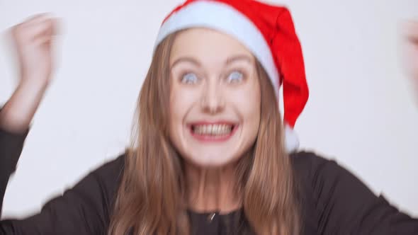 Cheerful Excited Young Pretty Fairhaired Girl in Christmas Hat Screaming Over White Background alt