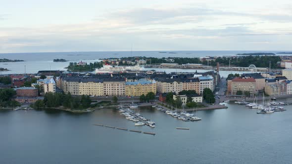 Slow aerial pan of Helsinki waterfront with cruise ship and ferris wheel in frame, Finland. alt