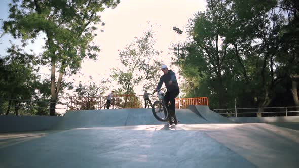 BMX Riders Doing Tricks in Extreme Park During Sunset Slow Motion alt