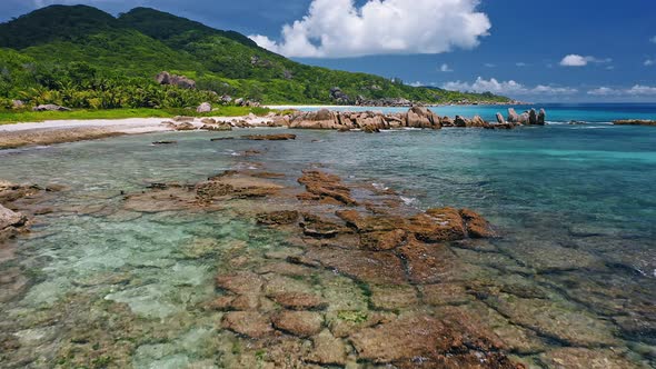 Aerial Drone Fly Above Shallow Tropical Coast with Rocks in Low Tide on Remote Beach alt