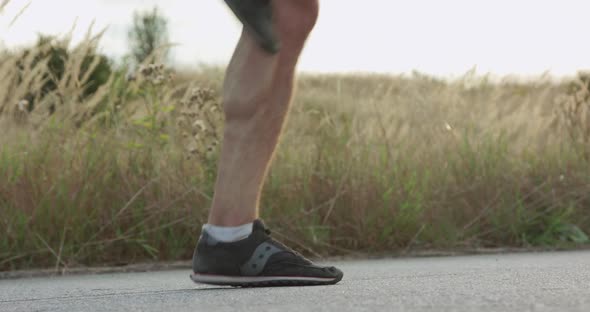 Low View of Sportsman's Legs Taking Turns Jumping on Skipping Rope on Walkway alt