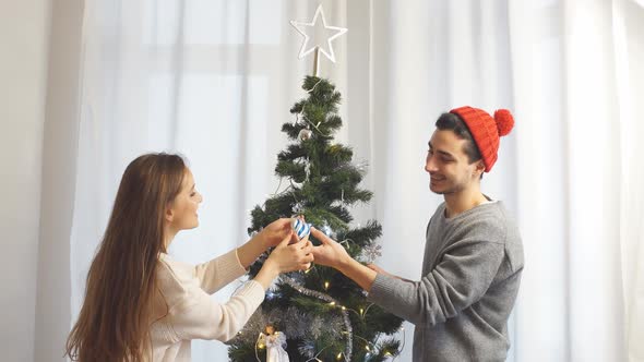 Loving Beautiful Couple Standing Dresses a Christmas Tree
