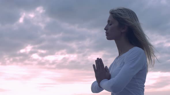 young woman in meditation near the sea: practicing yoga alt