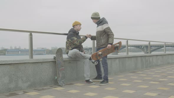 Teen Skaters Greeting Each Other Meeting Outdoors alt