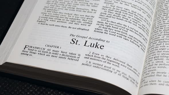 Close Up Shot of  Bible Page Turning to the book of Luke alt
