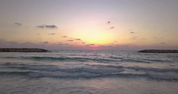 Gorgeous sunset over the Mediterranean Sea. Aerial shot over the Ocean while drifting towards the la alt