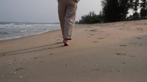 Closeup of a woman strolling on the beach by the sea