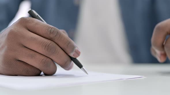 Close Up Young African Man Hand Writing Document  alt