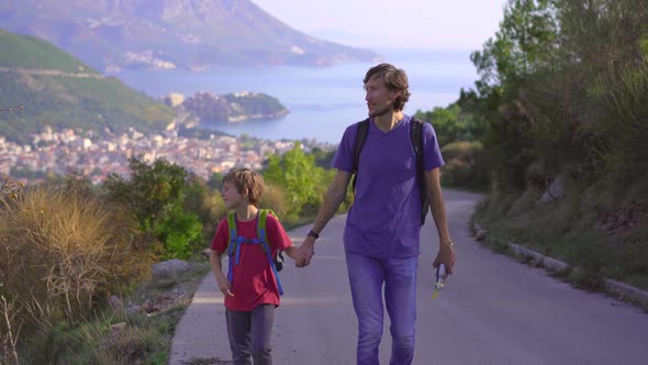 Young Man and His Son are on a Hike Above the City of Budva alt