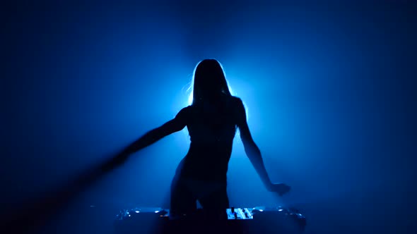 Blonde Woman Dj Plays Track and Erotically Dancing in Silhouette alt