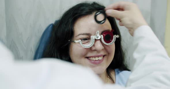 Close Up Eyesight Measurement To Young Woman with Optical Phoropter, Ophthalmologist Changes Lenses alt