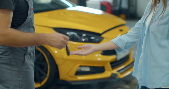 Mechanic Gives the Customer the Keys To His Repaired Car. Modern Clean Workshop with Cars. alt
