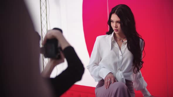 Young Attractive Model Woman Having a Photoshoot on Red Background alt