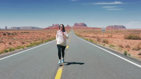 Young Caucasian Woman Exercising Outdoors Running with Red Mountains Background alt