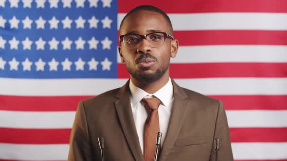 Afro-American Male Politician Giving Speech on U.S. Flag alt