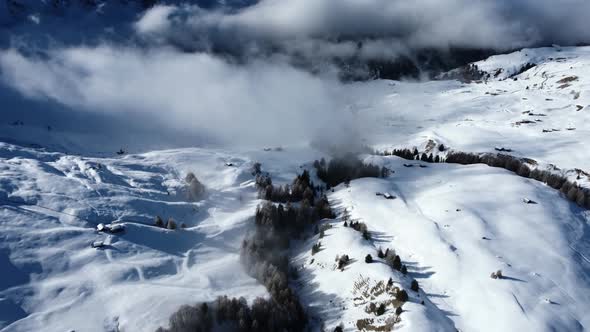 Slow pan up showing off the winter scenery in the Dolomites, while clouds are moving in front of the alt