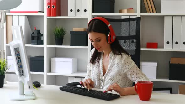 Businesswoman Listening Music and Typing on Keyboard