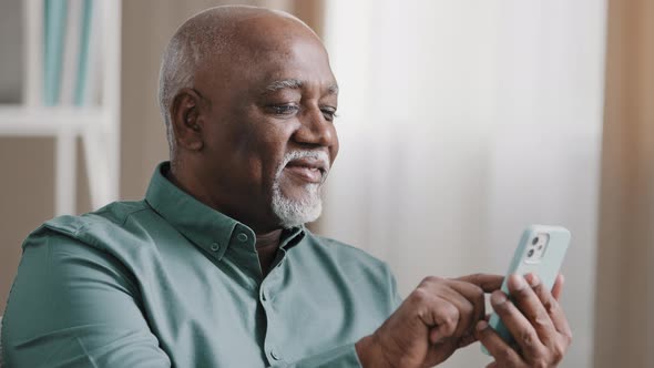 African Biracial Bald Old Man with Gray Beard Senior Mature Businessman Holding Cellphone Swiping in alt