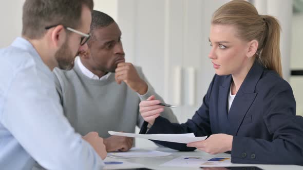 Businesswoman Explaining Documents to Male Colleagues alt