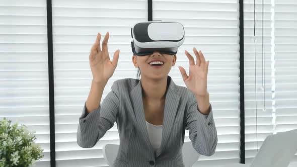 Asian woman use virtual reality glasses ( VR ) in her office