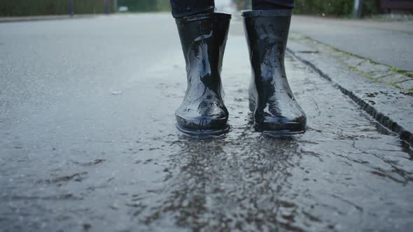 Woman In Boots Jumping In Rain Puddle