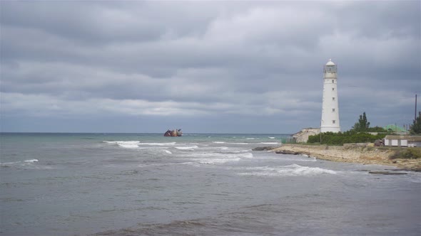 Seascape with Beautiful White Lighthouse Against Stormy Sk and Sea
