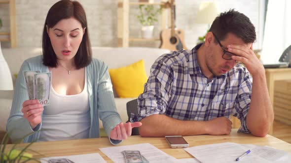 Close Up Young Couple Concerned and Tense Doing the Calculations Documents with Calculator alt