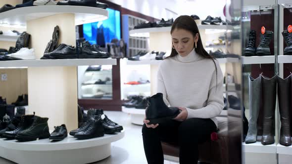 A Girl Chooses Shoes in a Clothing Store alt
