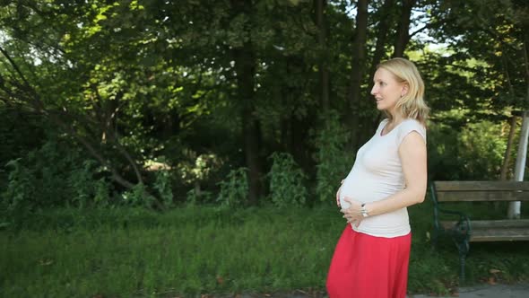 Pregnant Woman  Walking in Park alt